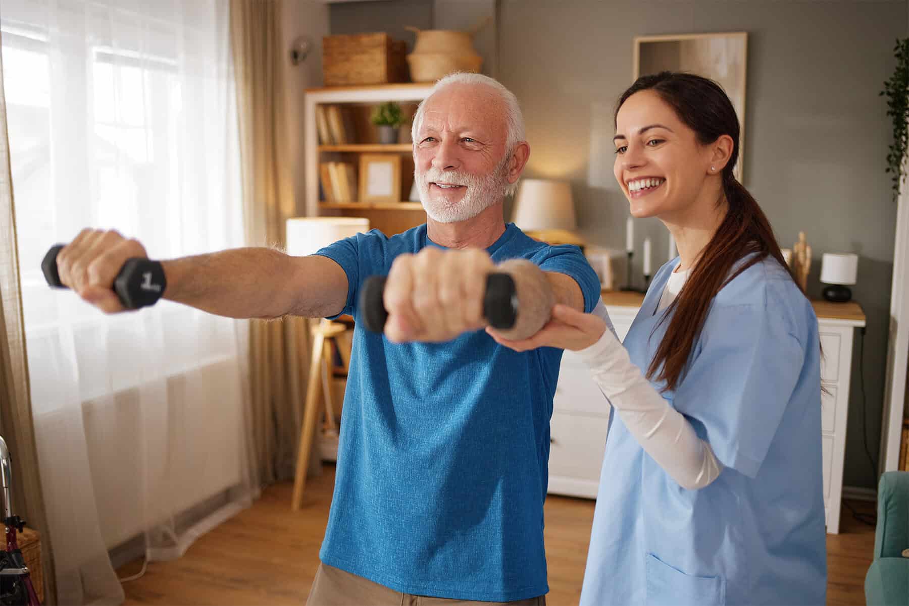 Elderly man doing arm exercises with a caregiver in a home setting, promoting health and wellness through personalized home health services.